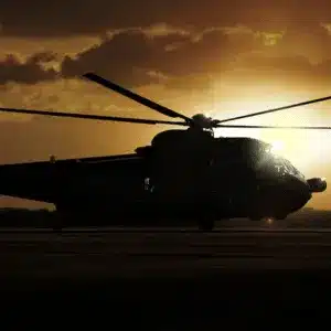 Helicopter stationed on runway at twilight equipped with aviation night vision goggles for visibility