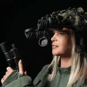 Female operator with firearm wears advanced ir vision goggles for enhanced night surveillance capabilities