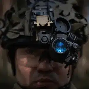 Soldier prepares ir vision goggles in outdoor setting for nighttime tactical reconnaissance operation