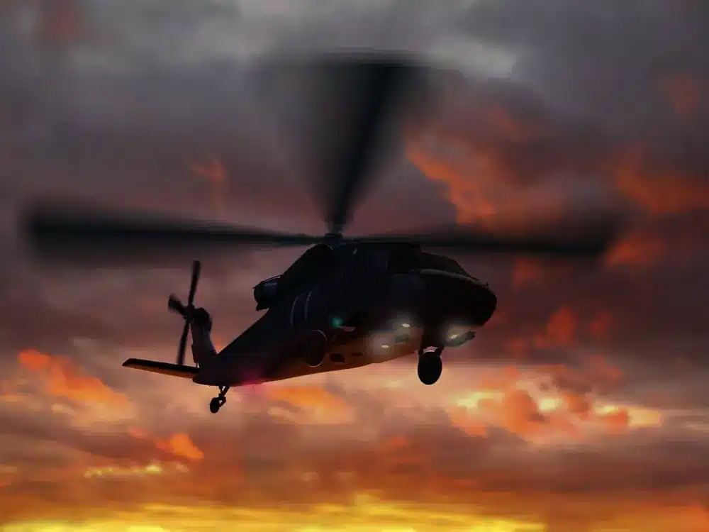 Military helicopter flying at dusk showcasing aviation night vision goggles in low-light operations