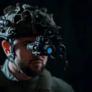 Man wears helmet-mounted ir vision goggles to improve visibility in low light environments