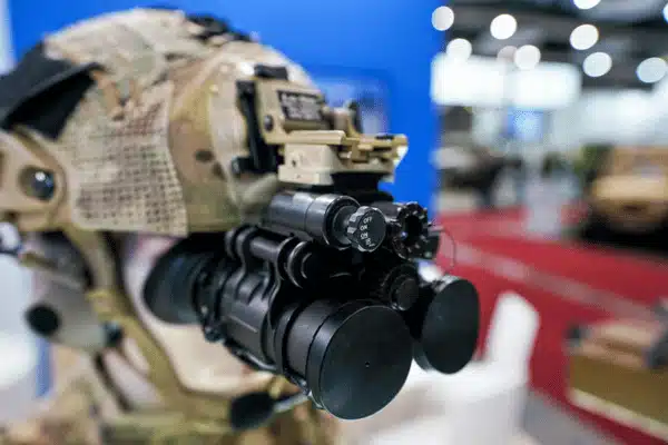 Closeup of helmet with night vision binoculars on display showing nvg models for tactical use