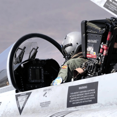 Rear view of pilot seated in fighter jet with gear showing nvg models integration onboard