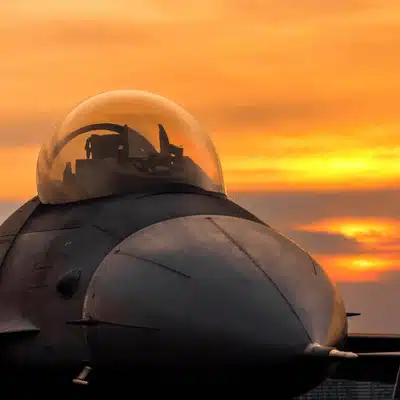 Silhouetted fighter jet on runway at sunset, illustrating fighter pilot night vision readiness training protocols
