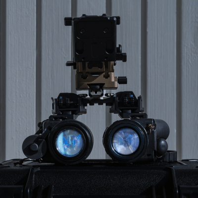 Mounted binocular night vision device on case, closeup lenses reflecting light, night vision goggles police