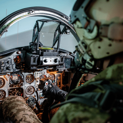Pilot sits in cockpit holding controls during flight training using nvg models for night operations