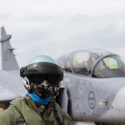 Photo shows pilot wearing flight helmet and oxygen mask near aircraft, representing nvg military operations
