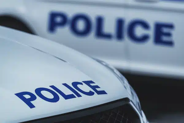 Closeup of police car hood lettering, showing patrol vehicles behind, night vision goggles police keyword