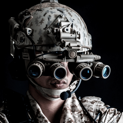 Soldier faces camera wearing quad-lens setup, demonstrating gen 3 night vision goggles for low light