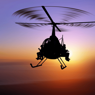 Helicopter silhouette at sunset carries soldiers, illustrating night vision range considerations during dusk operations training