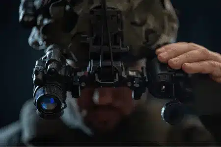 Soldier adjusts ir vision goggles for optimal clarity during tactical night operations mission